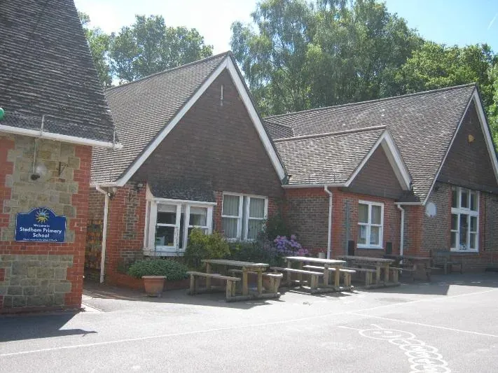 The school entrance with picnic benches on a sunny day