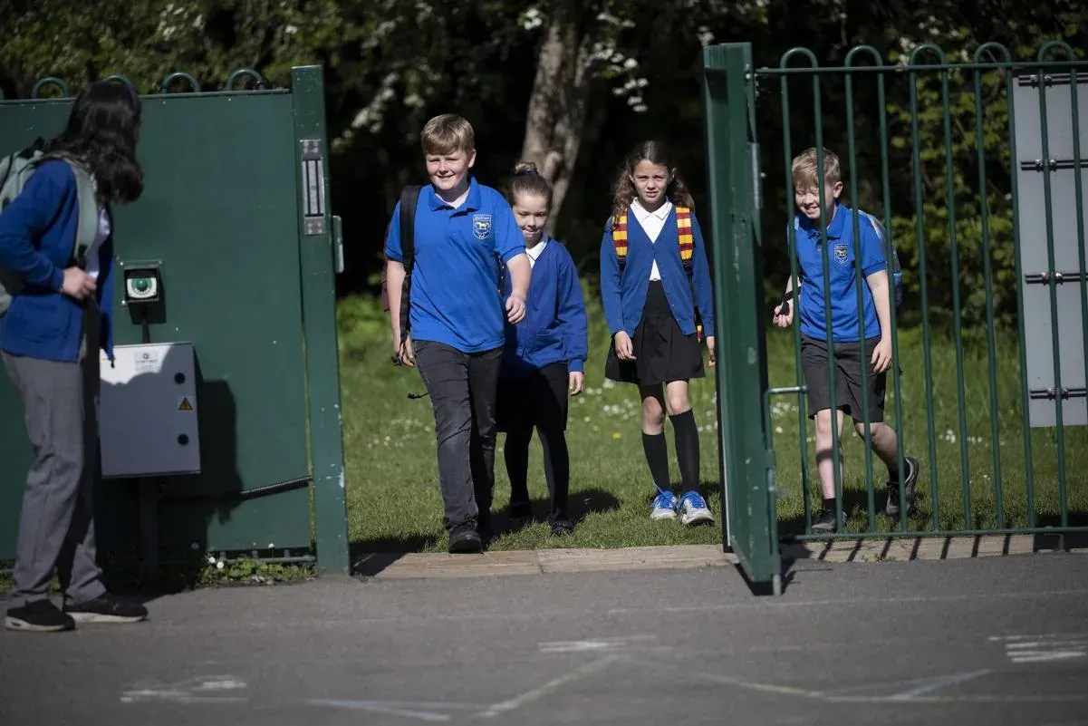 Pupils walking together through the school gate